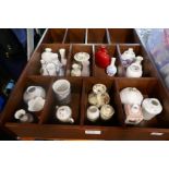 A wooden wall shelf containing various decorative vases and lidded pots