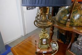 A gilt metal table lamp in the form of an urn