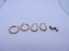 Pair of 9ct gold twisted hoop earrings, pair of 9ct gold creoles and pair of yellow metal studs