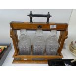 A Victorian oak Tantalus having silver mounts and three hobnail cut decanters