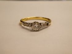 Antique 18ct and Platinum diamond ring with central round cut diamond and shoulders set with three s