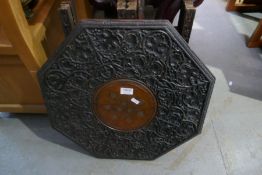 A Burmese carved octaganol table with folding base, the top inlaid brass flowers