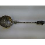 A white metal Church spoon having decorative scallop bowl and wrythen handle. With an ornate finial