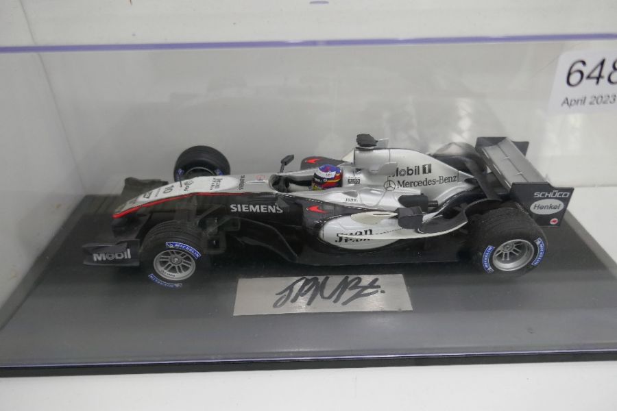 A model of a McLaren F1 car, signed by Juan Pablo Montoya, 1:18 scale, in case