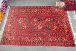 A red Afghan rug having three central medallions