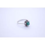 An 18ct white gold emerald and diamond cluster ring, with central oval cut emerald, surrounded 8 rou