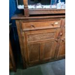 An oak sideboard having two drawers with carved panel doors below
