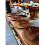 A set of four Japanese Terracotta wall plates having raised decoration of figures and cow, sizes are