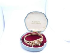 Very pretty 1960s 14ct yellow gold hinged bangle decorated lily pads, pearls and garnets, internal w