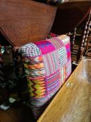 A large Afghan floor cushion and a stool having patchwork top