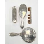 A silver backed dressing table set consisting of two brushes, a hand mirror and comb AF. Having deco