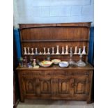 A reproduction oak dresser having carved front with rack back