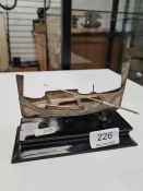 A Maltese model boat with a silver Malta 917 attachment on a stand. 16cm long approx AF