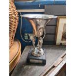 A 1960s silver plated trophy cup decorated three male figures with silver plaque