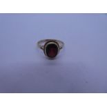 9ct yellow gold dress ring with oval faceted garnet in twisted gold frame, split shoulder, marked 37