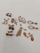 Collection of 9ct and yellow metal earrings including garnet set drop pair, tri-coloured example and