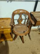 An old revolving desk chair with damaged cane seat