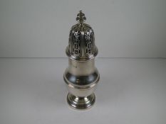A silver baluster caster having a similar shaped finial above a pierced domed pull-off lid. The base