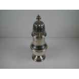 A silver baluster caster having a similar shaped finial above a pierced domed pull-off lid. The base