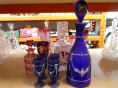 A blue glass decanter having painted decoration with 4 glasses, and sundry red glass items
