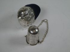 A novelty silver pin cushion of a chick, with the maker's mark Ari D Norman, London 1997. Also, with