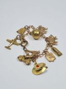 A plated charm bracelet, hung with 4 9ct gold charms to include a greyhound, pig, sheep and hot wate