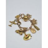 A plated charm bracelet, hung with 4 9ct gold charms to include a greyhound, pig, sheep and hot wate