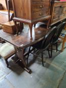 A reproduction refectory table having shaped top and set of stick back chairs