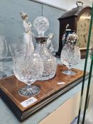 A brandy decanter having silver collar with pair of glasses on burr Walnut style stand