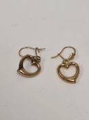 Pair of yellow metal drop earrings each suspended with a heart