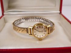 Vintage ladies gold plated Omega wristwatch with champagne dial, gold baton markers, winds and ticks