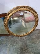 An Edwardian oval wall mirror and circular gilt mirror