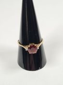 14K yellow gold ring with large circular faceted garnet with two small brilliant cut diamonds, marke