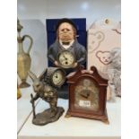 A reproduction figural clock of man with bow tie and two others