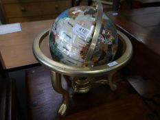 A modern table top globe having mineral coloured decoration