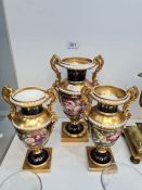 A derby style urn having painted panel of flowers with all over gilt decoration and a pair of matchi