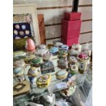 A shelf of pill boxes including enamel examples and a Victorian leather purse having silver cherub d