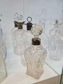 An old hobnail cut glass decanter having silver collar and three others, with silver collars