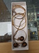 A tray containing five gold plated bangles, to include two gem stone set examples and three silver m
