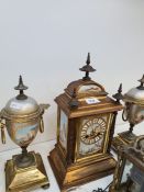 A gilt metal clock garniture, the clock having porcelain panels decorated coastal views, the clock 3