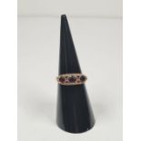 A 9ct gold half hooped ring, set with round cut garnets on decorative floral mount, marked 375 Birmi