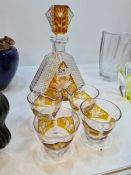 An Amber and clear glass decanter with 4 glasses