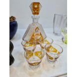 An Amber and clear glass decanter with 4 glasses