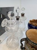 Two Edwardian glass decanters with silver collars and one other engraved brandy decanter decorated f