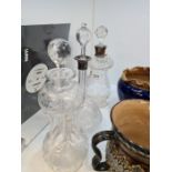 Two Edwardian glass decanters with silver collars and one other engraved brandy decanter decorated f