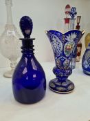 A bohemian blue and clear glass vase having painted floral panels and a Bristol blue glass decanter
