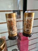A pair of 19th Century Satsuma vases of cylindrical form decorated figures on hardwood bases, 12cm
