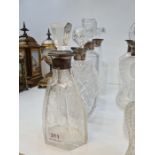 Three glass decanters having silver collars and one other engraved decanter with plated collar