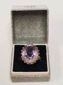 9ct yellow gold dress ring set with a large pale amethyst oval mixed cut, on decorative raised mount