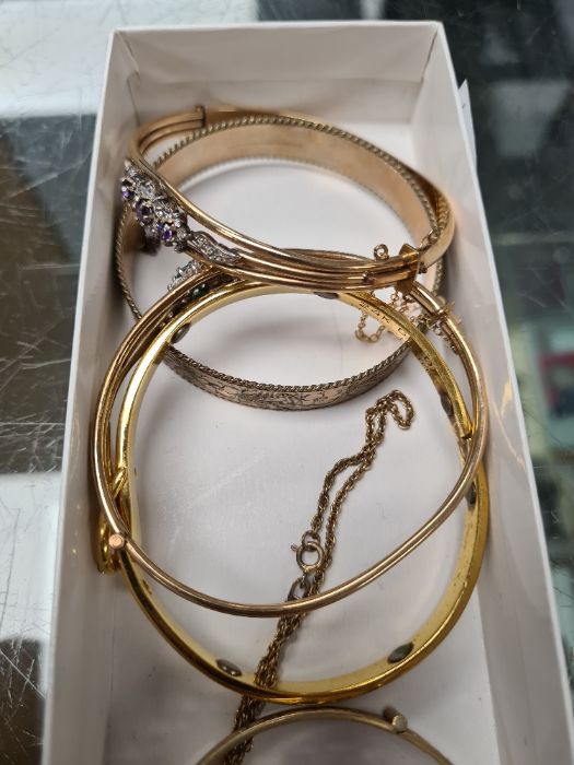 A tray containing five gold plated bangles, to include two gem stone set examples and three silver m - Image 3 of 3
